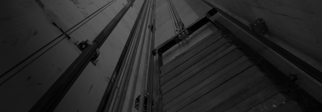 Vista técnica de un contrapeso de ascensor instalado en el hueco, mostrando las pesas de hierro fundido y el sistema de guiado.