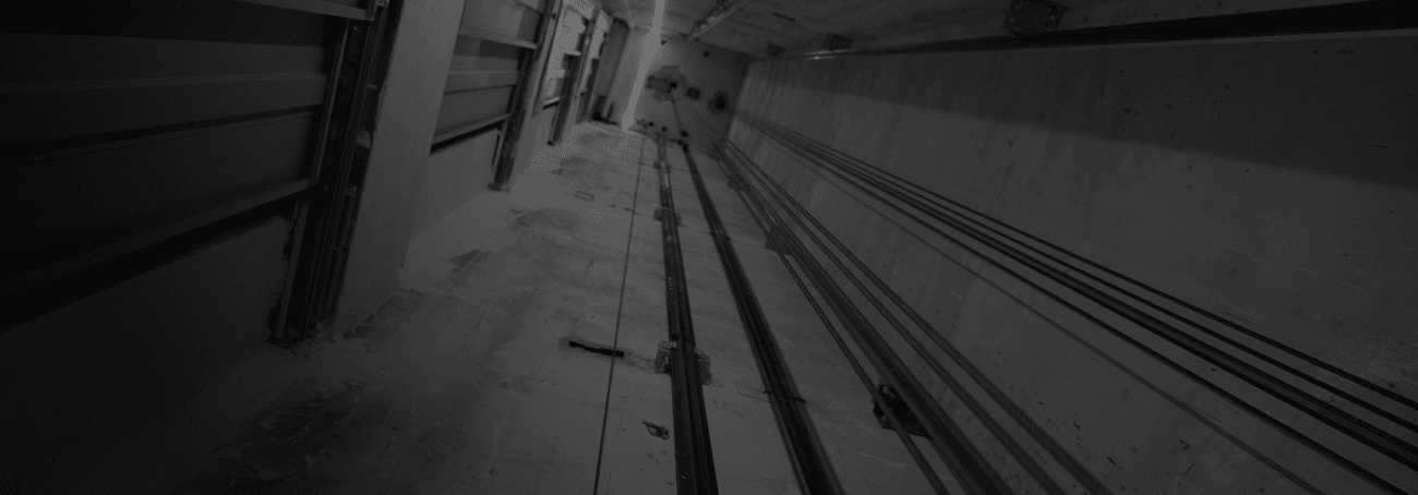 Vista detallada de las guías de acero calibrado instaladas en el hueco durante un proyecto de modernización de Ascensores Domingo.